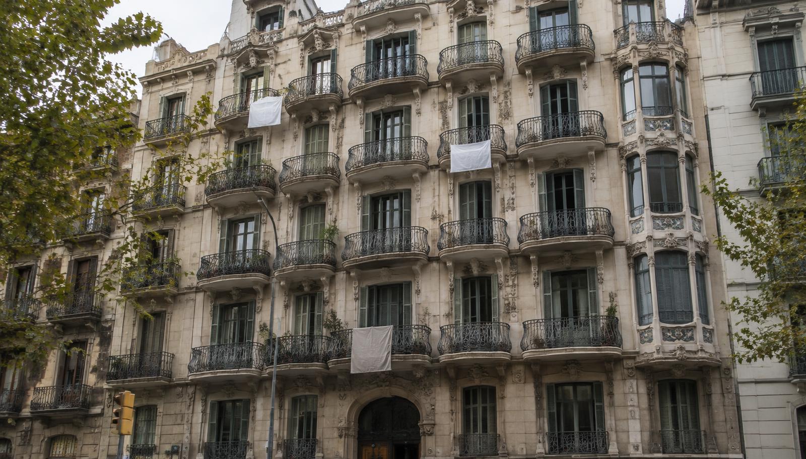 Altbaufassade im Barcelonaer Eixample mit Tüchern an den Balkonen